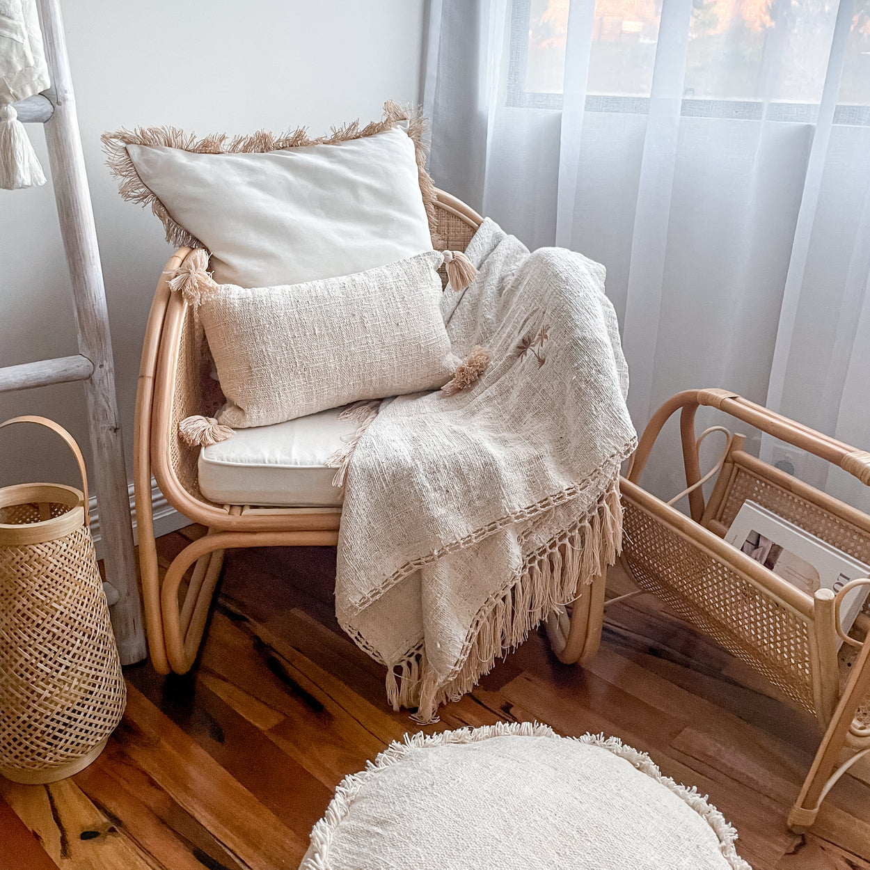 Rattan chair with cushions and a blanket in a cozy room and rattan magazine rack 